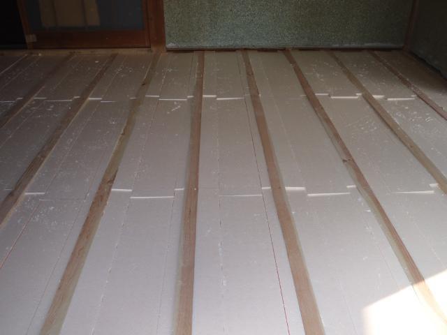 防蟻完了後、根太の間に隙間ができないよう、注意しながら断熱材を敷き込みます。