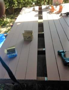 床の下地が完了後、床板をきれいに並べて取り付けます。今回の床板は木だけでなく木樹脂（木と樹脂を混ぜ合わせて作った材料）を専用の止め具（ステンレス製）で止めていきます。
