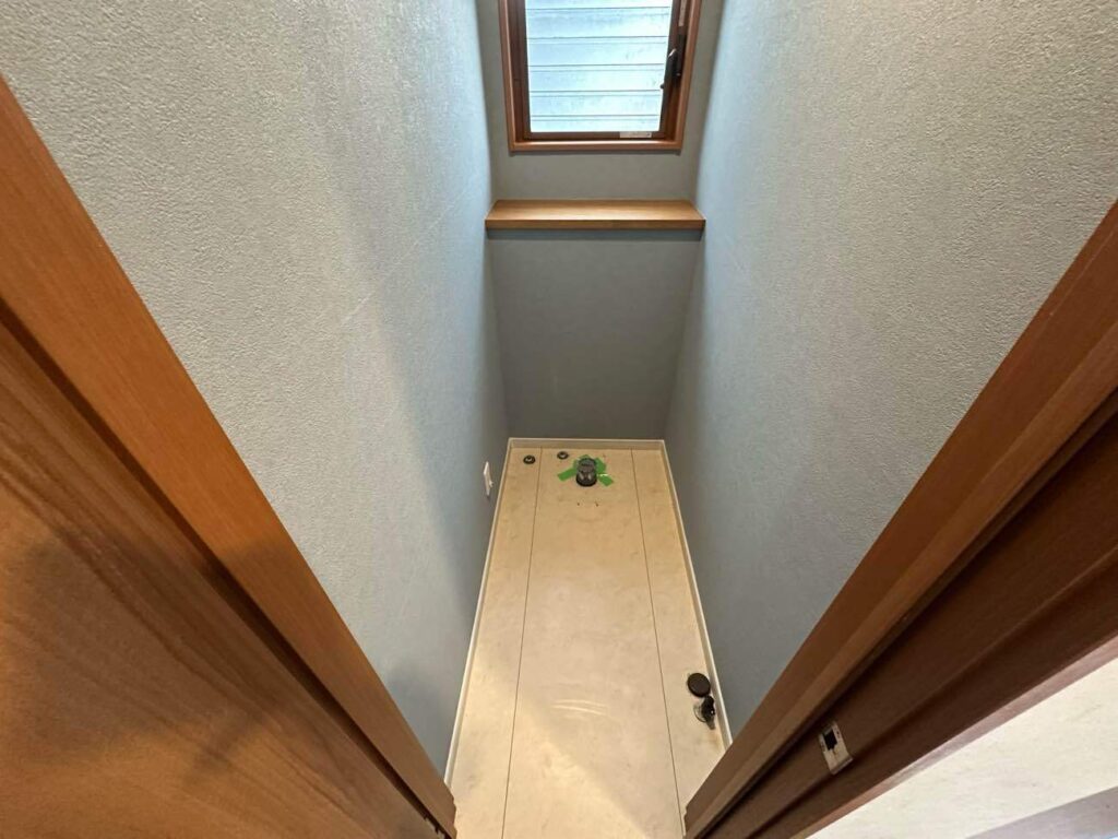 問題の排水管の位置変更を終え、床は張り替えないので、床の部分の配管後はプラグ処理を行い、壁紙の張り替えも完了しました。便器は無くても雰囲気はだいぶ変わりましたね。